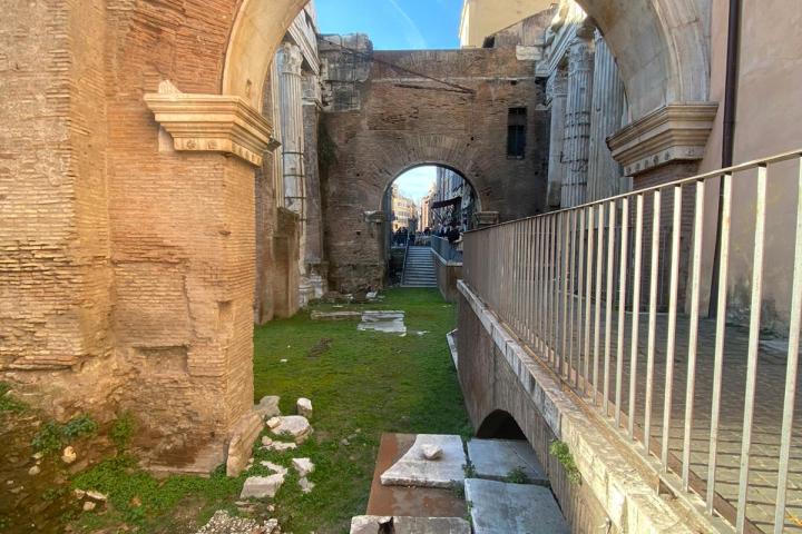 a stone building that has a bridge next to a brick wall