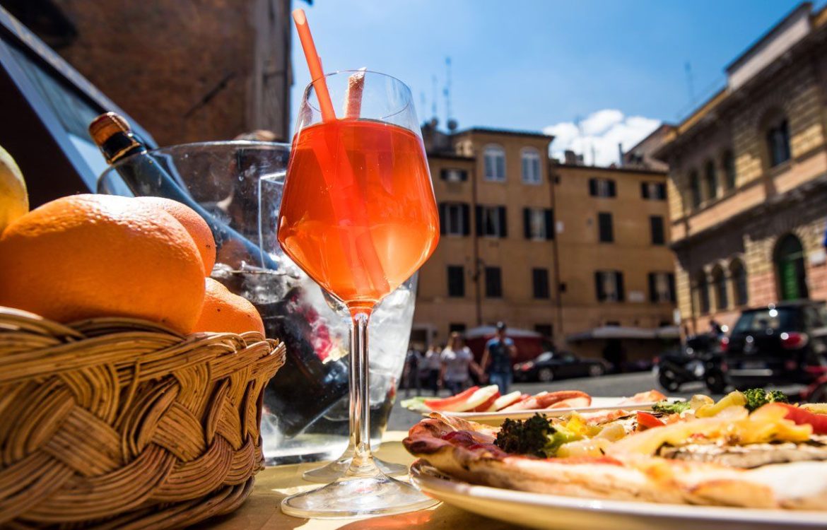 aperitivo-rome-1170×750 a plate of food and a glass of orange juice