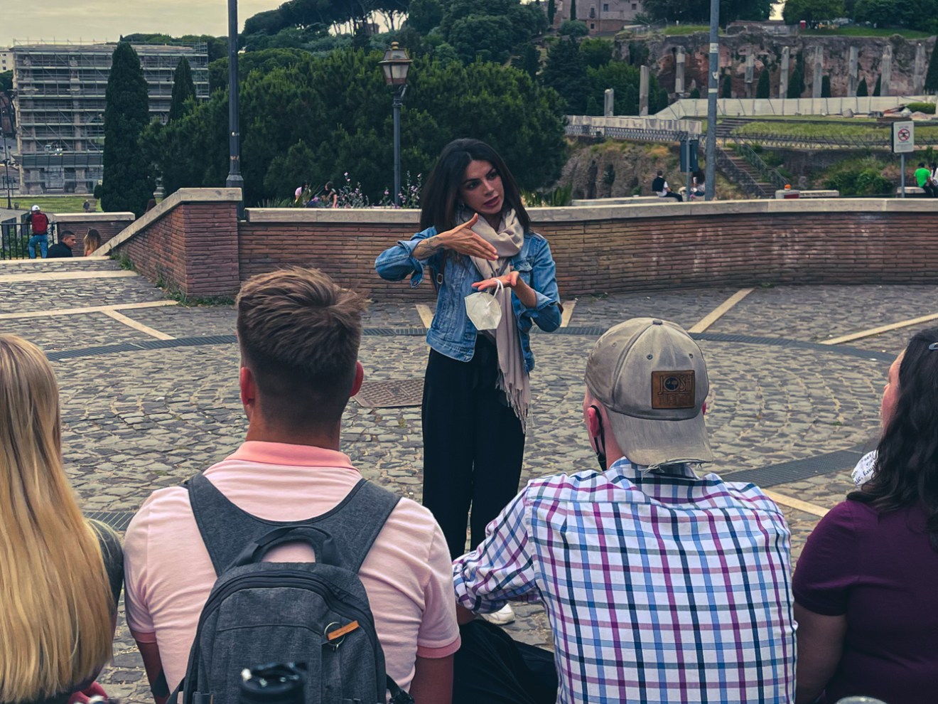 a group of people standing next to a bottle of wine