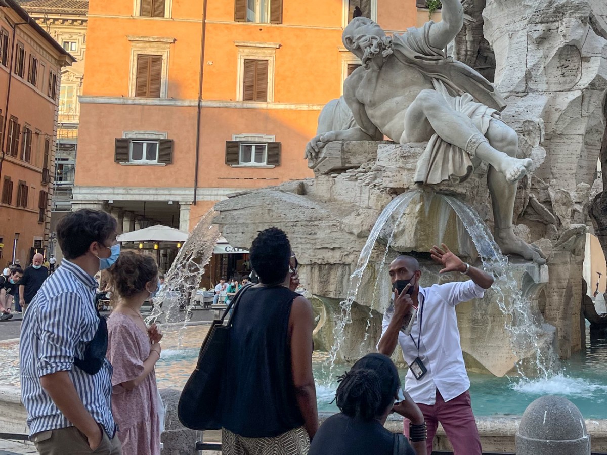 a group of people standing in front of a statue